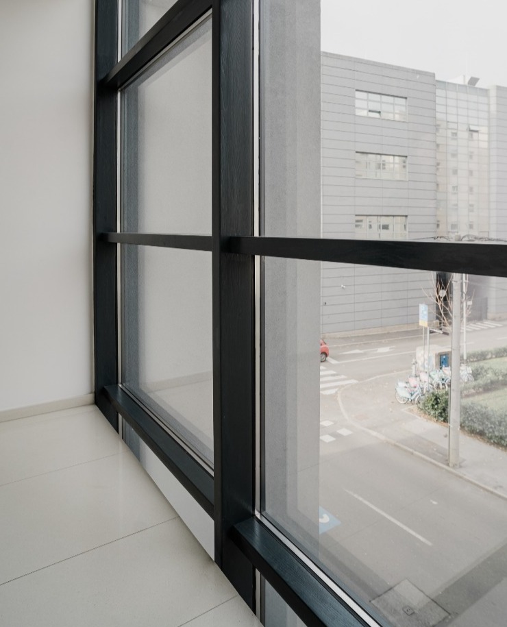 prozor tamno sivog okvira i pogled na vanjski dio građevnog sklopa