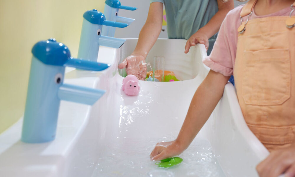 djeca peru ruke u dečjem umivaoniku i igraju se